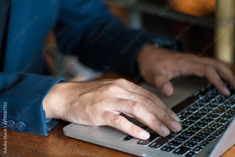 Close up Asian business man using laptop for working in coffee shop in selective focus. Close up Asian business man using laptop for working in coffee shop in selective focus.