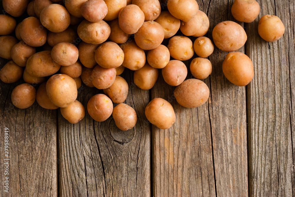 petite potatoes on rustic wood table background petite potatoes on rustic wood table background