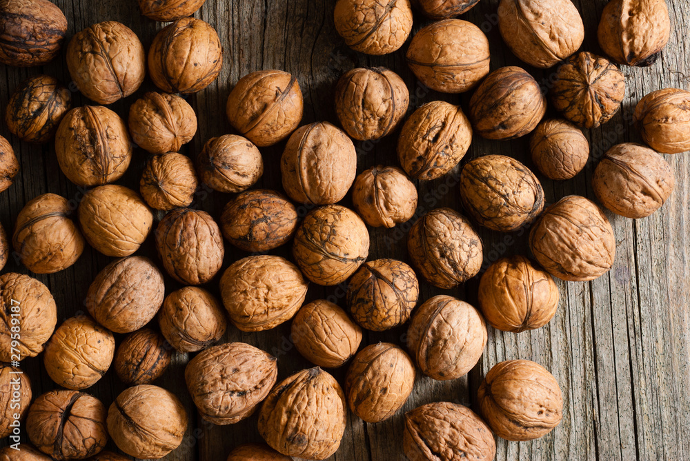 walnuts on old wooden table directly above walnuts on old wooden table directly above