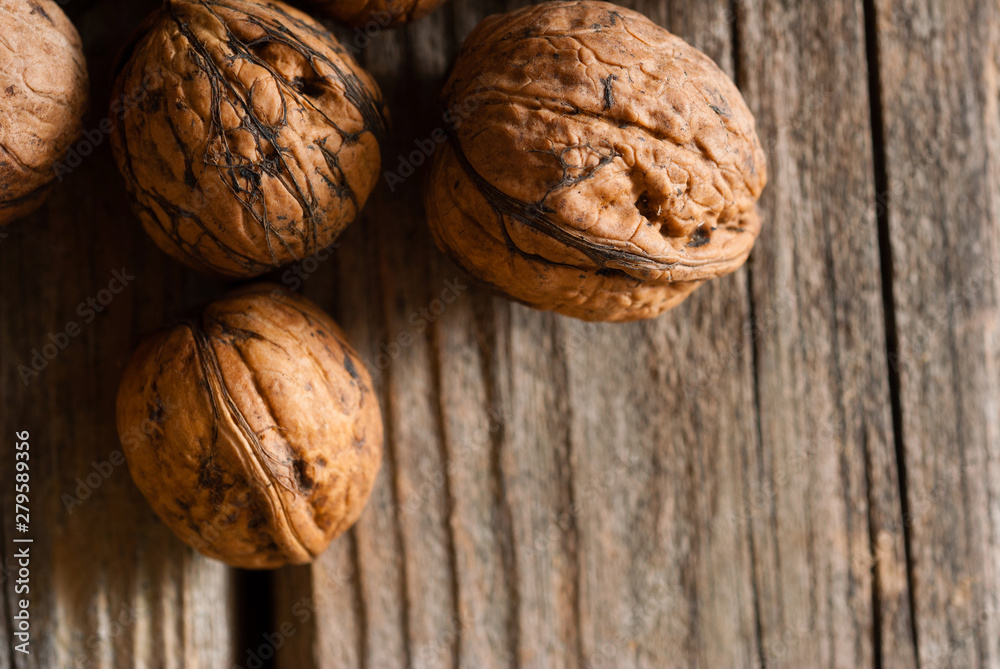 walnuts on old wooden table directly above walnuts on old wooden table directly above