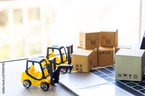 Mini forklift truck load cardboard boxes with text online shopping and symbols on laptop keyboard. Logistics and transportation management ideas and Industry business commercial concept.