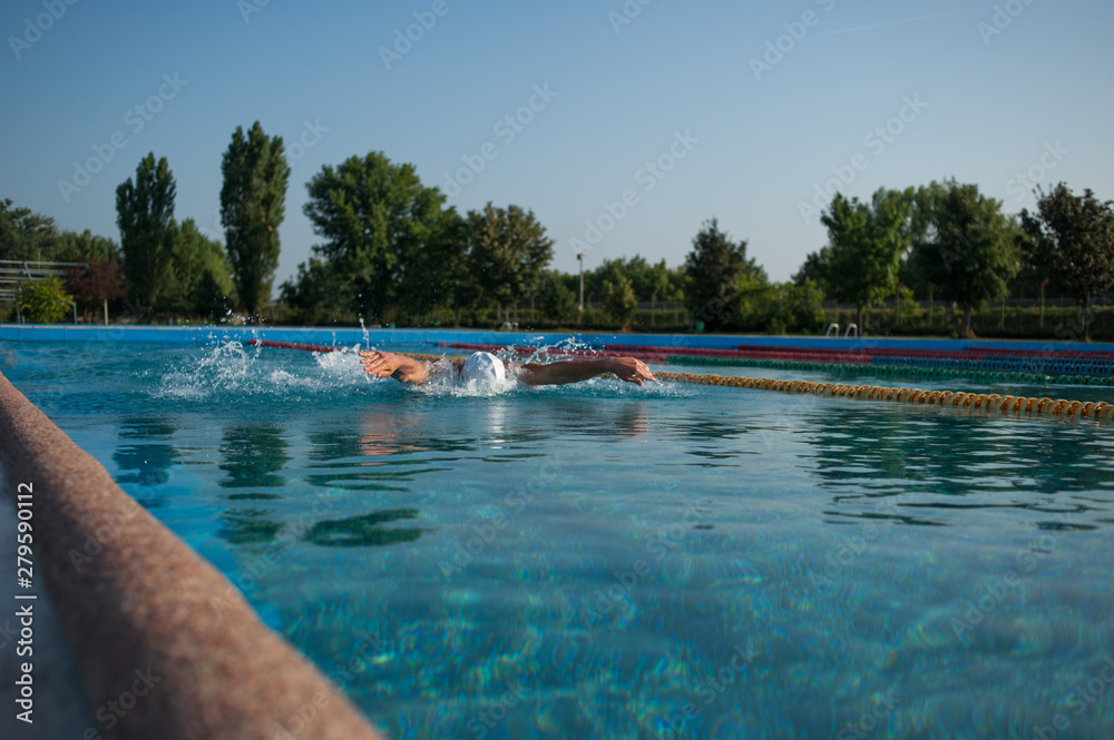 Swimmer standing next to a pool on a sunny morning