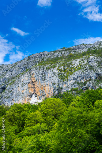 Montenegro, Ancient building of ostrog monastery carved out of rock wall cliff visited by hundreds of thousands pilgrims every year to see miracles on holy ground