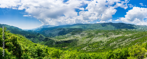Montenegro, XXL panorama view of green valley bjelopavlici plain lowlands from mountains near ostrog monastery with blue sky and thunderstorm clouds
