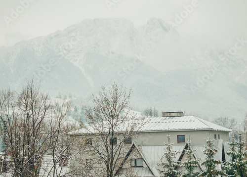 Foggy tatra mountains in winter with building on front.