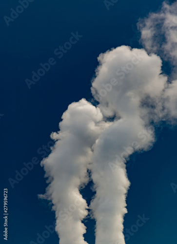 White smoke from pipes of thermal power plant in the dark blue sky