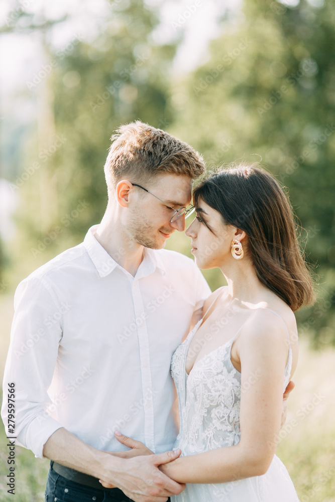 Happy couple outdoors at sunset. A stylish wedding in the European style of fine art. Happy couple outdoors at sunset. A stylish wedding in the European style of fine art.