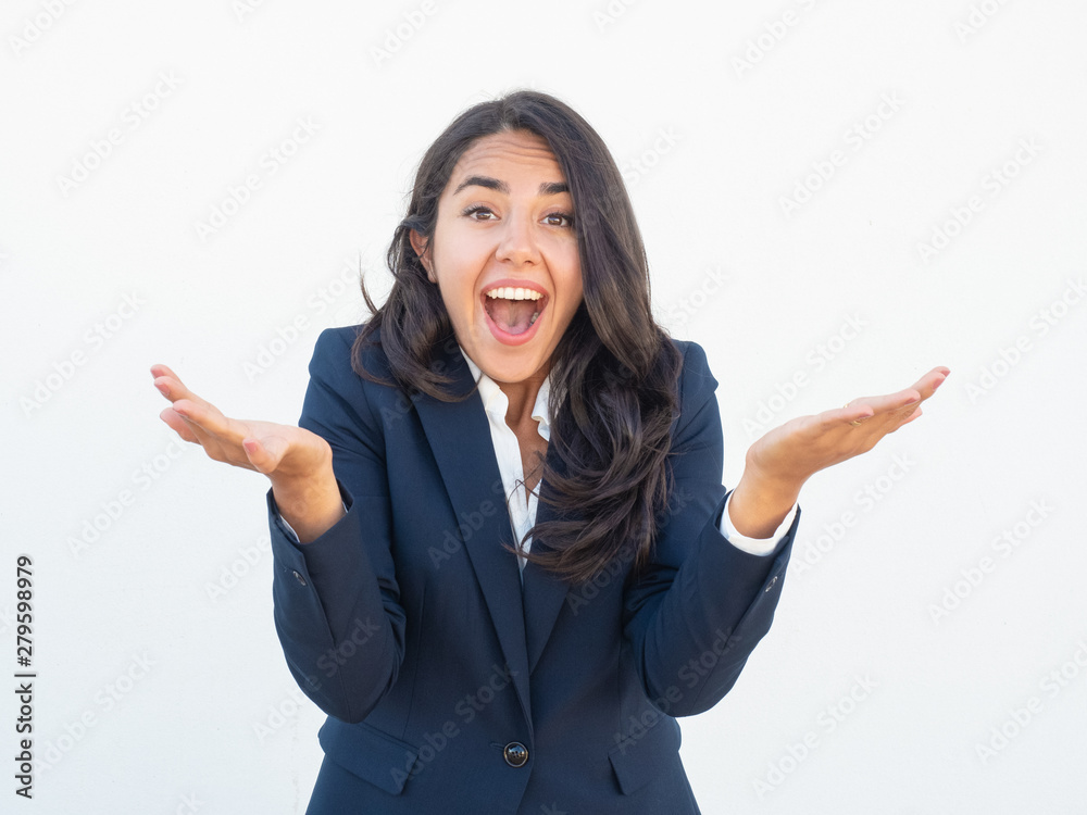 Excited businesswoman extremely shocked with good news. Young Latin woman in office suit gesturing with hands and shouting in surprise. Shocked or overjoyed woman concept Excited businesswoman extremely shocked with good news. Young Latin woman in office suit gesturing with hands and shouting in surprise. Shocked or overjoyed woman concept
