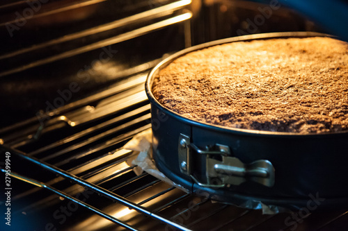 Pie in a special baking dish in the electric oven in the kitchen. View of the finished baked pie from the oven with the door open. Apple wheat big muffin.