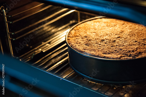 Pie in a special baking dish in the electric oven in the kitchen. View of the finished baked pie from the oven with the door open. Apple wheat big muffin.