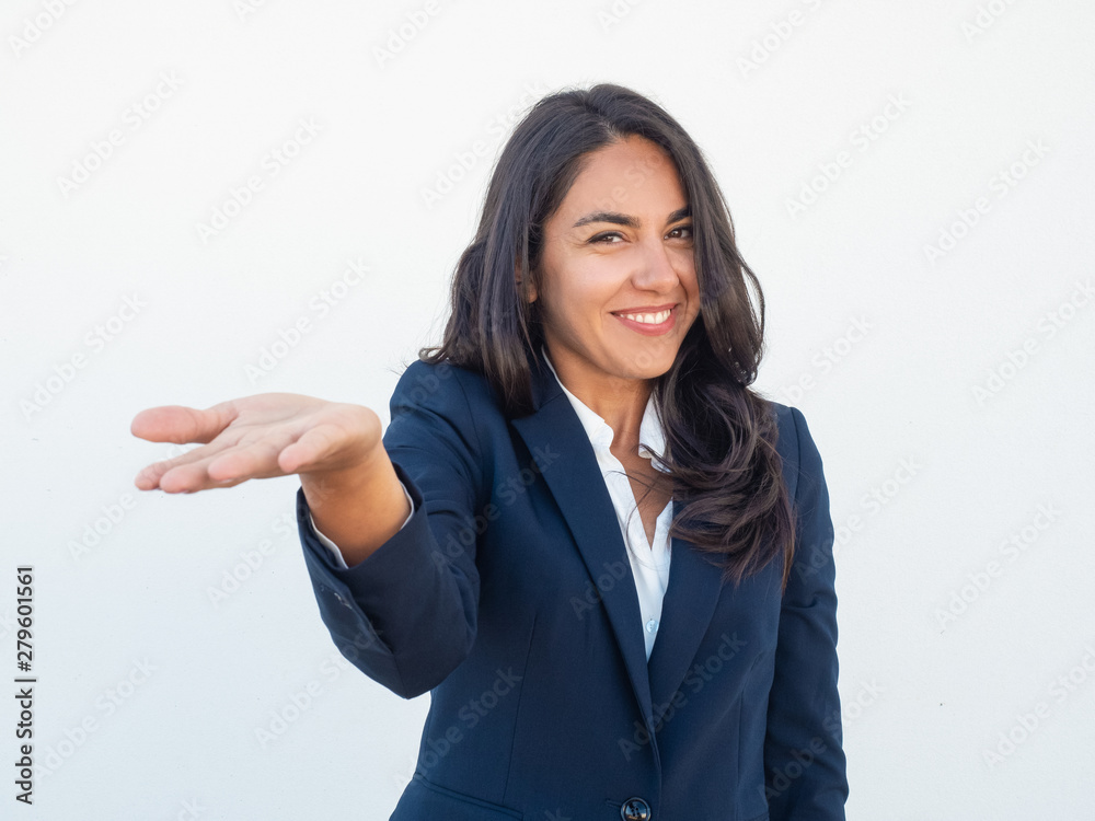 Joyful positive business leader holding something in hand. Young Latin woman in office suit outstretching hand and showing empty copy space on palm. Presentation concept Joyful positive business leader holding something in hand. Young Latin woman in office suit outstretching hand and showing empty copy space on palm. Presentation concept