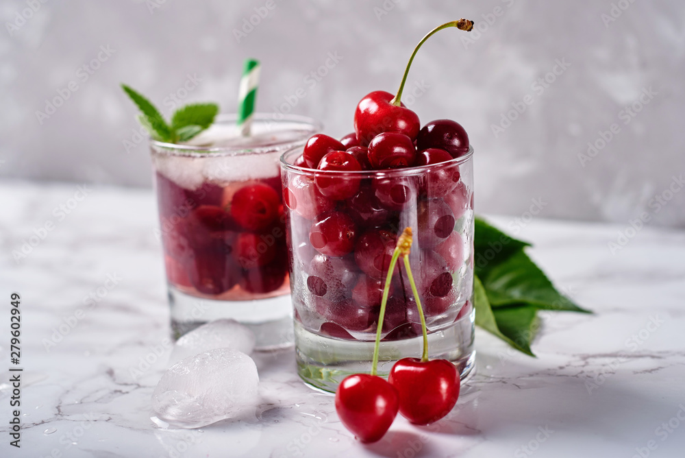 Fresh ripe cherries in sparkling glass on gray table background, copy space Fresh ripe cherries in sparkling glass on gray table background, copy space