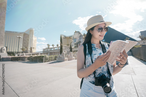 Sphinx and pyramid of Cheops in backgorund under blue sky. young female traveler visit resort and casino in Las Vegas Strip in Nevada United States. woman tourist holding guide book read information photo