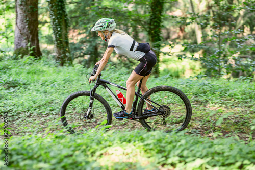 Sportive woman cycling on a off road path
