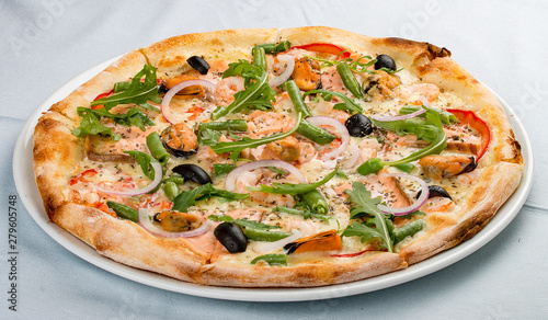 Delicious hot pizza with salmon, mussels, olives, tomatoes and various spices. On white background