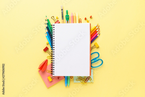 Colorful school stationery and supplies on yellow background.