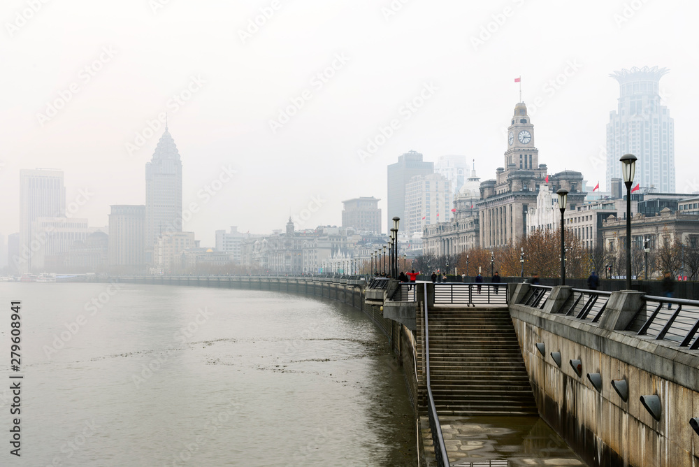 Historical architecture on the bund of Shanghai with reflection of buildings on rain and mist in city, the Bund is a popular tourist destination of Shanghai, China