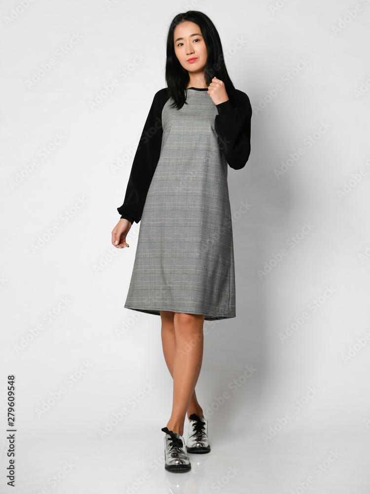 Young beautiful woman posing in new fashion winter dress full body on a white Young beautiful woman posing in new fashion winter dress full body on a white