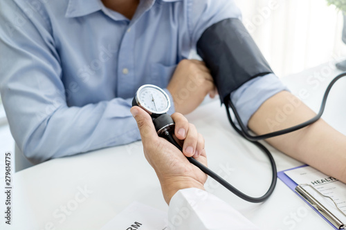 The doctor is checking the blood pressure of the patient. photo