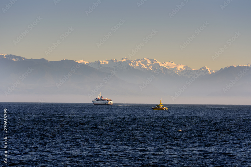 View of Olympic Penninsular at Sunset with Ship and patrol boat from Victoria, Canada View of Olympic Penninsular at Sunset with Ship and patrol boat from Victoria, Canada