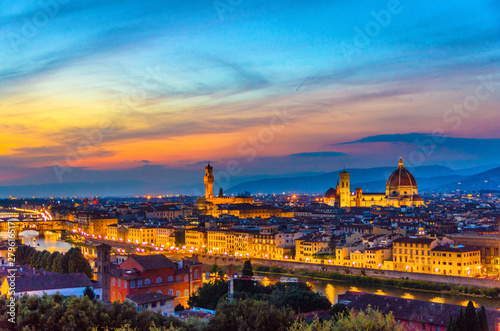Top aerial panoramic evening view of Florence city with Duomo Santa Maria del Fiore cathedral, Arno river, Ponte Vecchio bridge and Palazzo Vecchio palace at night dusk, city lights, Tuscany, Italy © Aliaksandr