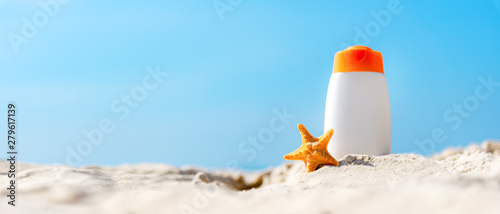 Protective sunscreen or sunblock and sunbath lotion for healthy care skin woman in white plastic bottles with starfish on tropical beach, summer accessories in holiday, copy space for text banner.  