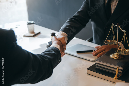 Businessman shaking hands to seal a deal with his partner lawyers or attorneys discussing a contract agreement.