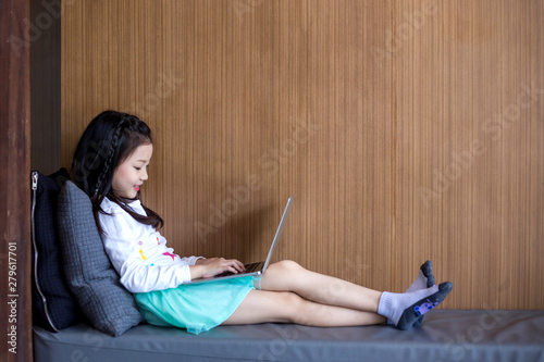 Schoolgirl using laptop in the house.