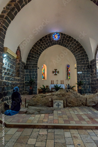 Tabgha, Israel - May 18 2019: Nun praying in the Church of the multiplication of the loaves and fishes in Tabgha, Israel