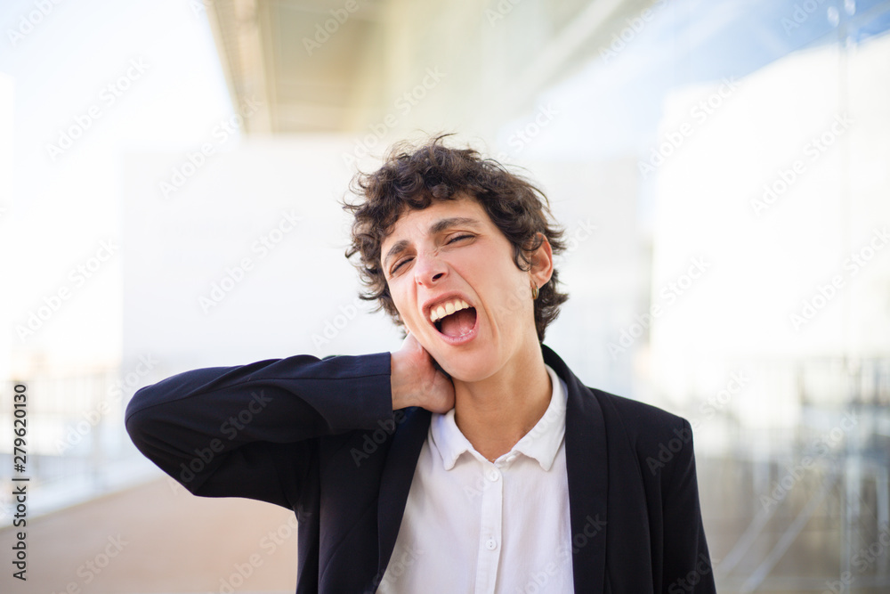 Sleepy businesswoman yawning. Tired middle aged businesswoman in formal wear rubbing neck. Overworked concept Sleepy businesswoman yawning. Tired middle aged businesswoman in formal wear rubbing neck. Overworked concept