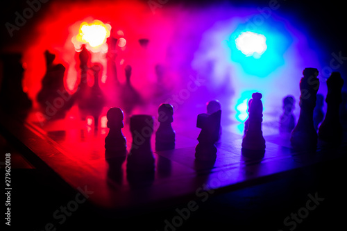 Chess board game concept of business ideas and competition. Chess figures on a dark background with smoke and fog. © zef art