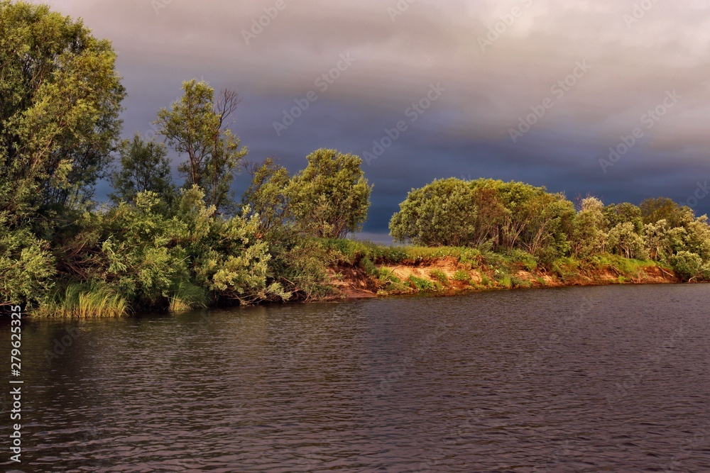 landscape with river, green trees and cloudy sky