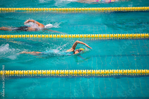 Athlete in freestyle swimming race in swimming pool