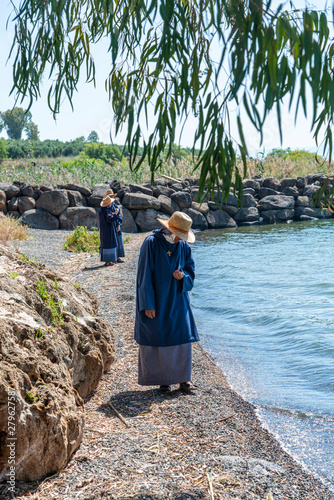 Tabgha, Israel - May 18 2019 : Nuns visiting the shore of Sea of Galilee in Tabgha church