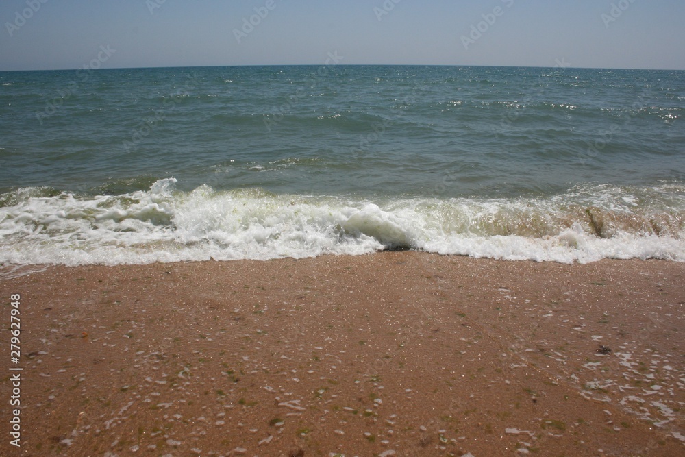 beach with clear water and waves in the sea