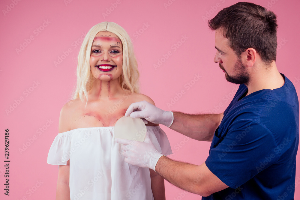 Flawless face of young beautiful blonde long hair patient woman and doctor surgery consulting about breast augmentation mammoplasty,choose new bust gel implant improvement size Flawless face of young beautiful blonde long hair patient woman and doctor surgery consulting about breast augmentation mammoplasty,choose new bust gel implant improvement size