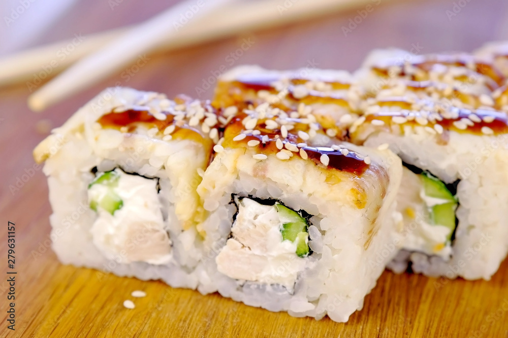 Rolls with fish and sesame seed on top served in wooden board Rolls with fish and sesame seed on top served in wooden board