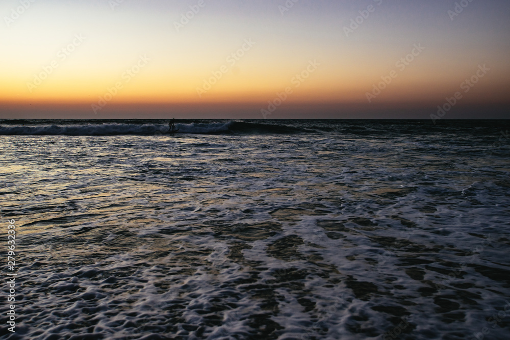Surfer in the sea at sunset Sidi Kaouki, Morocco