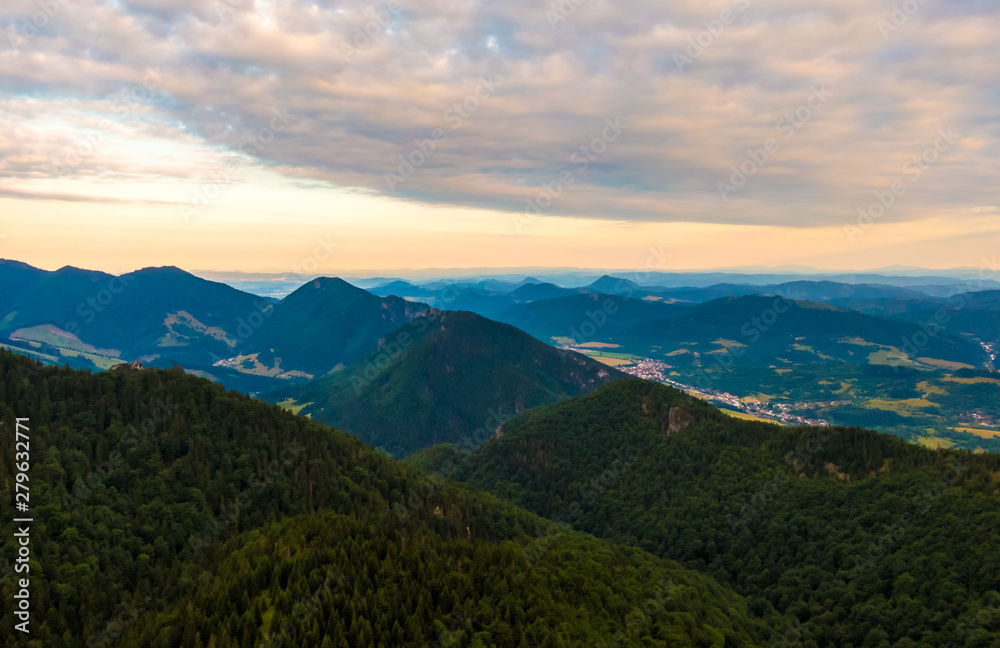 Aerial view to Mala Fatra mountains in Slovakia. Sunrise above mountain peaks and hills in far. Beautiful nature, vibrant colors. Famous tourist destination for hiking and trekking. Cloudy weather. Aerial view to Mala Fatra mountains in Slovakia. Sunrise above mountain peaks and hills in far. Beautiful nature, vibrant colors. Famous tourist destination for hiking and trekking. Cloudy weather.