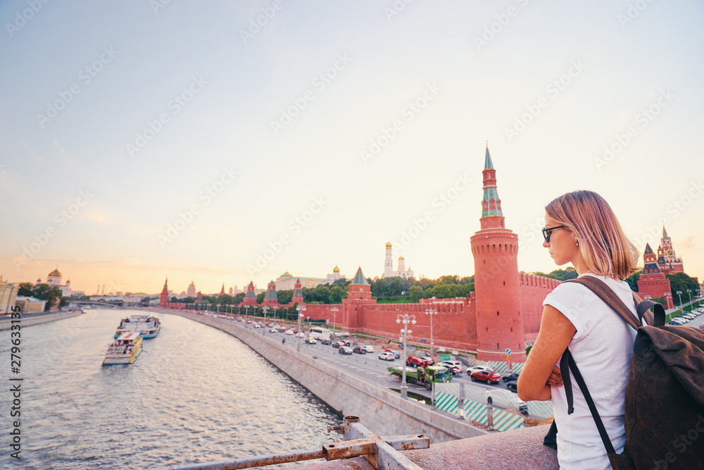 Traveling by Russia. Young woman with rucksack enjoying Kremlin and Moscow River view. - obrazy, fototapety, plakaty 