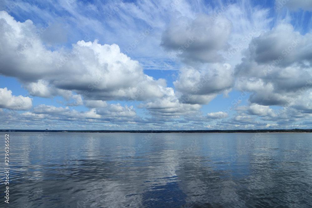beautiful seascape calm, cumulus clouds reflected in sea water panorama