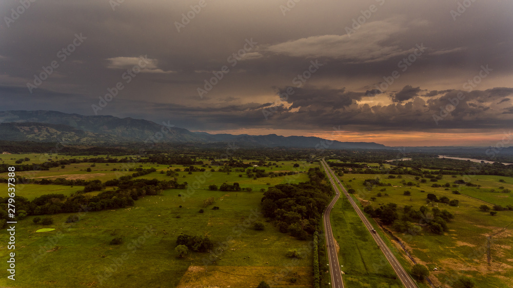 Fototapeta sunset over green field