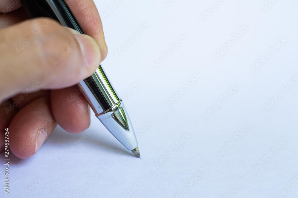 Woman's left Hand holding a silver pen, writing letter on white paper background, Notebook, Close up & Macro shot, Selective focus, Communication, Stationery concept Woman's left Hand holding a silver pen, writing letter on white paper background, Notebook, Close up & Macro shot, Selective focus, Communication, Stationery concept