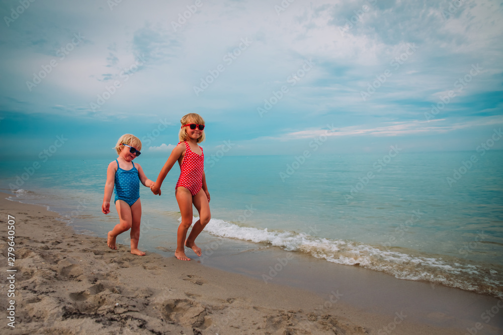 cute little girls go swim on beach vacation