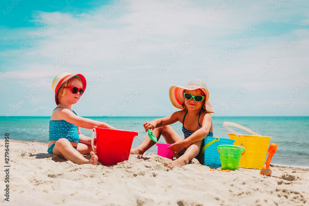 cute little girls play with sand on summer beach cute little girls play with sand on summer beach