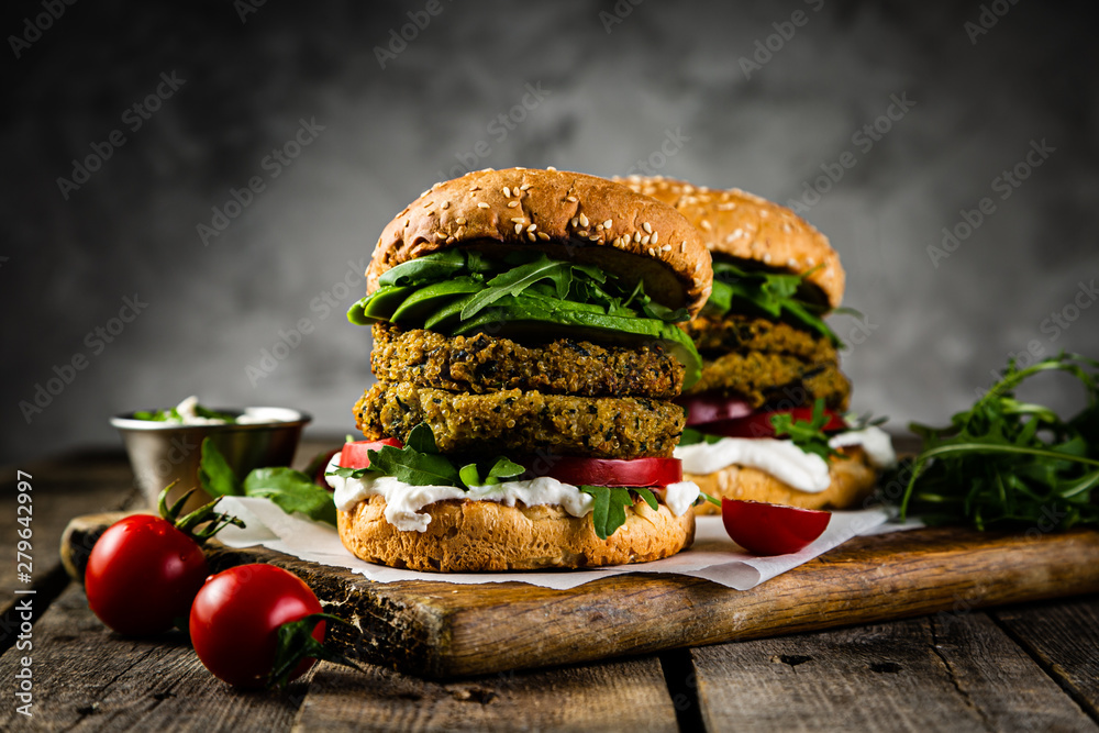 Vegan zucchini burger and ingredients on rustic wood background, copy space - obrazy, fototapety, plakaty 