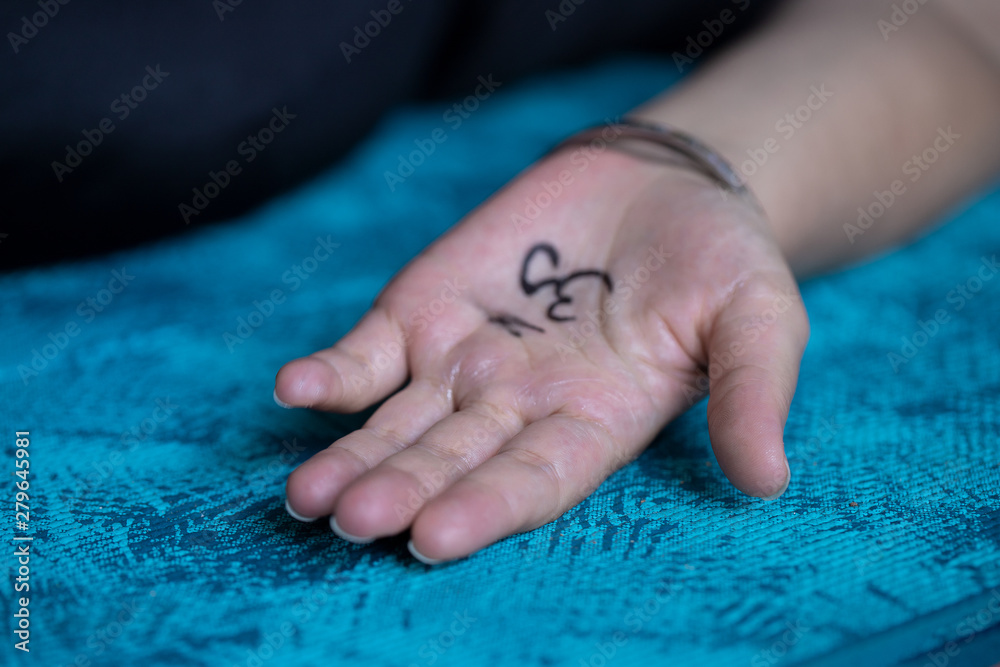Close up of female hand with painting Om symbol on the yoga mat. Yoga concept background. Close up of female hand with painting Om symbol on the yoga mat. Yoga concept background.