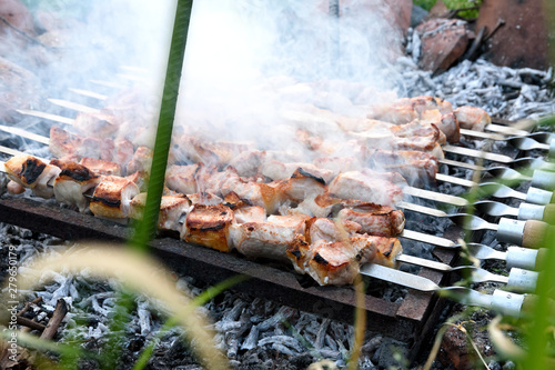 Pork shashlyk preparing on barbecue grill over charcoal from grapevine. Kakhetian cooking method photo