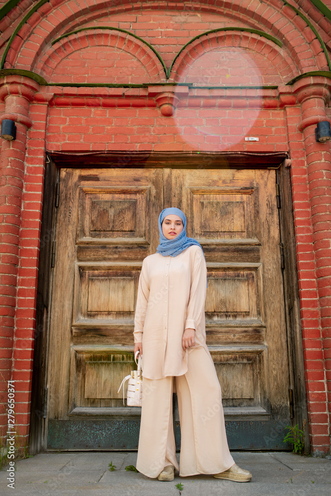 Young Muslim woman in blue hijab and beige casualwear