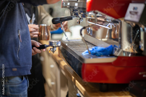 Barista makes coffee in the coffee machine another Barista teaches you to do it